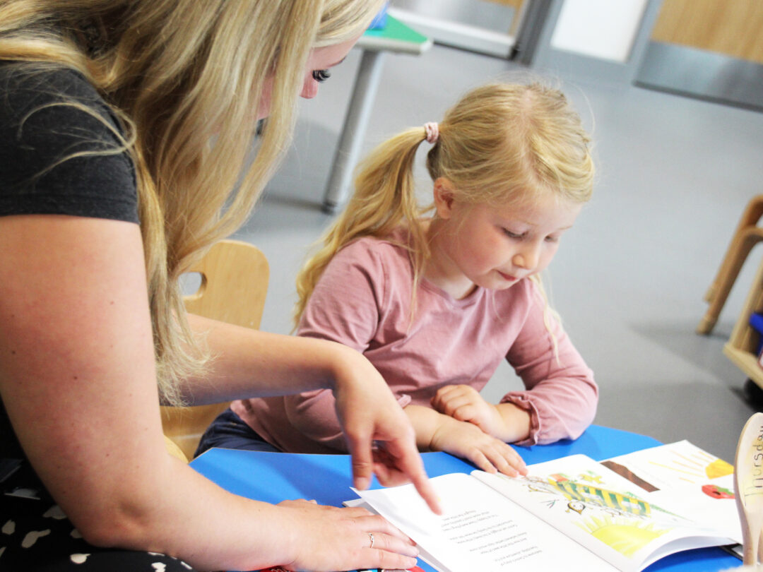 Lady reading book with girl